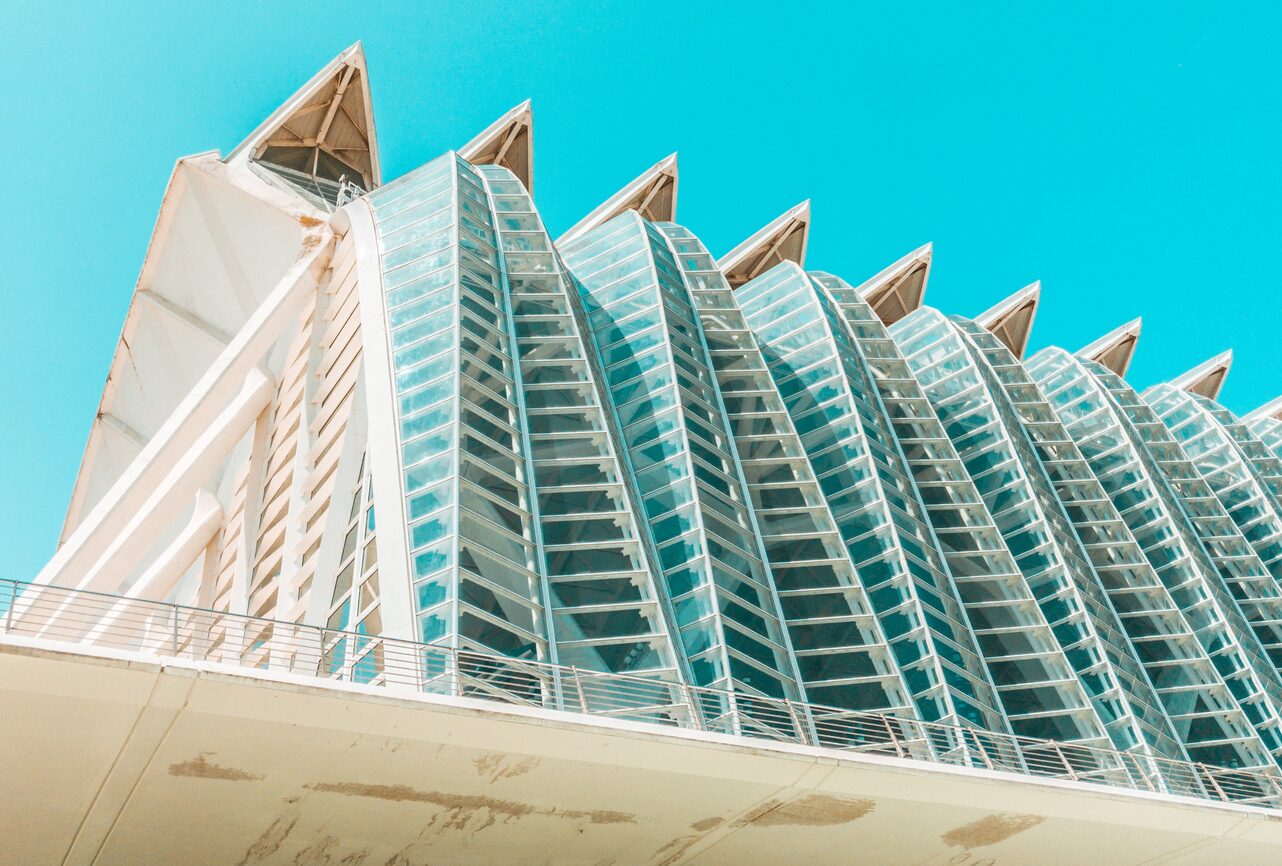 The glazed façade of a modern university building against a clear sky.
