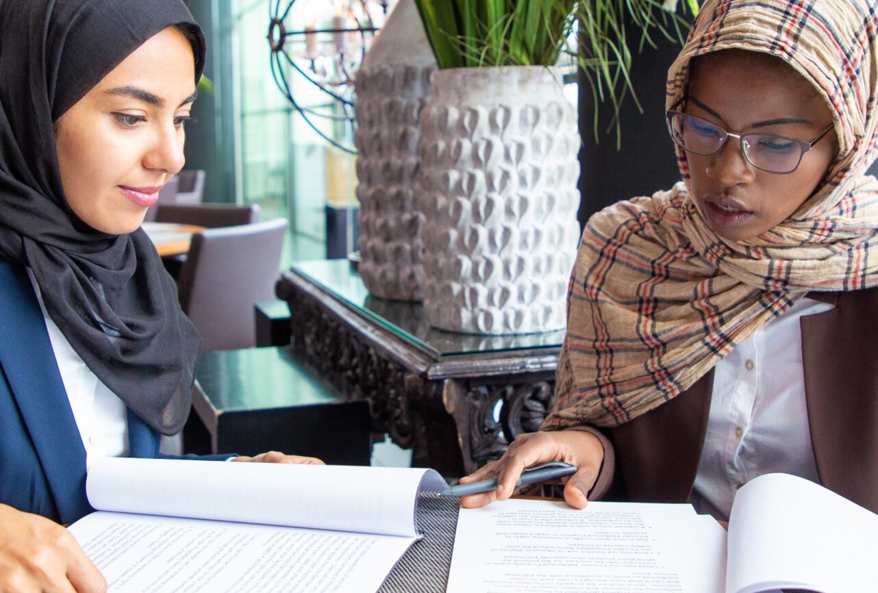 Two colleagues reviewing a printed agreement together at a table.